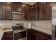 Stylish kitchen showcasing stainless steel appliances, dark wood cabinets, and light countertops at 5520 White Marlin Ct, New Port Richey, FL 34652