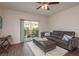 Living room with wood floors, ceiling fan, leather sofa, and access to the balcony at 5520 White Marlin Ct, New Port Richey, FL 34652
