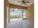 Enclosed sunroom with textured walls, ceiling fan, and a view of the fenced backyard and stone landscaping at 5520 White Marlin Ct, New Port Richey, FL 34652