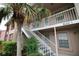 Building 1 shows a exterior stairway, tropical landscaping, and neutral paint at 6338 Spring Flower Dr # 21, New Port Richey, FL 34653