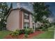Two story home with brick trim and freshly manicured landscaping, shrubs, and trees at 6338 Spring Flower Dr # 21, New Port Richey, FL 34653