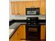 Kitchen features black appliances and wooden cabinets at 6462 92Nd N Pl # 806, Pinellas Park, FL 33782