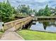 Scenic pond featuring a charming gazebo, wooden bridge, and lush landscaping at 6462 92Nd N Pl # 806, Pinellas Park, FL 33782
