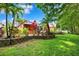 Lush backyard featuring mature trees, a well-maintained lawn, privacy fence, and tasteful landscaping at 6505 Broadwing Ct, Tampa, FL 33625