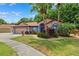 Charming one-story home with a well-manicured front lawn, tropical landscaping, and a two-car garage at 6505 Broadwing Ct, Tampa, FL 33625