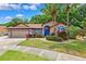 Charming one-story home with a well-manicured front lawn, tropical landscaping, and a two-car garage at 6505 Broadwing Ct, Tampa, FL 33625