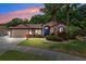 Charming single-story home featuring lush landscaping, a two-car garage, and a vibrant blue trim at 6505 Broadwing Ct, Tampa, FL 33625