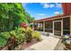 Relaxing screened patio featuring a lovely garden view and a pathway to the house at 6505 Broadwing Ct, Tampa, FL 33625