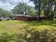 Lush backyard with green grass and a red fence surrounding the property at 717 Whiteway Dr, Brooksville, FL 34601