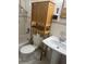 Functional bathroom with a pedestal sink, toilet, and over-the-toilet storage at 717 Whiteway Dr, Brooksville, FL 34601