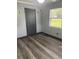 Cozy bedroom with wood-look floors, a gray door, and natural light at 717 Whiteway Dr, Brooksville, FL 34601