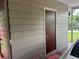 Simple exterior with a door and horizontal beige vinyl siding at 717 Whiteway Dr, Brooksville, FL 34601