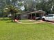 Charming single-story home with a covered carport, palm tree, and well-maintained front lawn at 717 Whiteway Dr, Brooksville, FL 34601