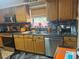 This kitchen features stainless steel appliances, warm wood cabinetry, and dark countertops at 717 Whiteway Dr, Brooksville, FL 34601