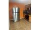 Modern kitchen with stainless steel refrigerator and appliances, complimented by tile floors at 717 Whiteway Dr, Brooksville, FL 34601