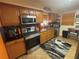 Well-lit kitchen with stainless steel appliances, including a microwave and dishwasher at 717 Whiteway Dr, Brooksville, FL 34601