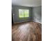 Inviting living room featuring wood-look flooring and natural light from a large window at 717 Whiteway Dr, Brooksville, FL 34601