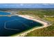 A wide aerial view of a beach and lake with a wakeboarding park and sandy shoreline at 7303 Hatteras Dr, Hudson, FL 34667