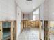 Hallway with tile flooring and studs, ready for renovation at 7303 Hatteras Dr, Hudson, FL 34667