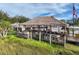 Outdoor restaurant with a tiki hut, bar seating, and lush surroundings, perfect for waterfront dining at 7303 Hatteras Dr, Hudson, FL 34667