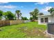Spacious backyard with a lush green lawn and a partial view of the house at 7316 Tangelo Ave, Port Richey, FL 34668