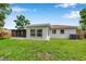 Backyard view showing the screened in patio, large windows, and an AC unit at 7316 Tangelo Ave, Port Richey, FL 34668