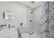 Modern bathroom featuring a marble tiled shower, toilet and round vanity mirror at 7316 Tangelo Ave, Port Richey, FL 34668
