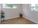 Bright bedroom featuring wood-look floors and 2 large windows at 7316 Tangelo Ave, Port Richey, FL 34668