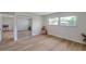 Bright bedroom featuring wood floors, a mirrored closet, and a large window at 7316 Tangelo Ave, Port Richey, FL 34668