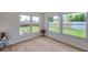 Bright bedroom featuring wood-look floors and multiple large windows at 7316 Tangelo Ave, Port Richey, FL 34668