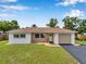 Inviting home exterior with neutral paint, a manicured lawn, and ample parking at 7316 Tangelo Ave, Port Richey, FL 34668