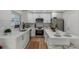 Well-lit kitchen with stainless steel appliances, white countertops, a kitchen island, and wood flooring at 7316 Tangelo Ave, Port Richey, FL 34668