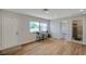 Bright living room with wood floors, natural light, and a view to the bathroom at 7316 Tangelo Ave, Port Richey, FL 34668
