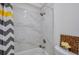Elegant shower with white marble tile surround and a stylish showerhead at 7316 Tangelo Ave, Port Richey, FL 34668