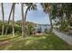 Picturesque backyard with a dock, a fire pit, mature trees, and waterfront views at 7424 Grand Blvd, New Port Richey, FL 34652