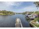 Waterfront view featuring a private boat dock on a tranquil canal, with lush greenery and neighborhood views at 7424 Grand Blvd, New Port Richey, FL 34652