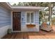 Close up of front entrance, showcasing the wood door and adjacent outdoor lounge area at 7424 Grand Blvd, New Port Richey, FL 34652