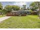 Charming home featuring a spacious front yard and a large wooden deck with seating at 7424 Grand Blvd, New Port Richey, FL 34652