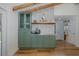 Charming kitchen showcases custom green cabinetry, quartz countertops, tiled backsplash and a functional coffee bar at 7424 Grand Blvd, New Port Richey, FL 34652