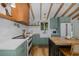 Bright kitchen with custom green cabinetry, stainless steel appliances, and open shelving at 7424 Grand Blvd, New Port Richey, FL 34652