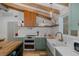 Charming kitchen boasts green cabinetry, farmhouse sink, modern appliances, and stylish wood accents and shelving at 7424 Grand Blvd, New Port Richey, FL 34652