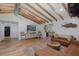 Spacious living room featuring beamed ceilings, hardwood floors, stylish furnishings, and a convenient wet bar at 7424 Grand Blvd, New Port Richey, FL 34652