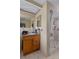Bathroom features a single sink vanity, framed mirror, walk-in shower with a seat and tiled flooring at 7608 Dale Dr, Port Richey, FL 34668