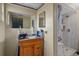 Bathroom features a single sink vanity, framed mirror, walk-in shower and tiled flooring at 7608 Dale Dr, Port Richey, FL 34668