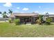 Backyard showcasing screened-in lanai, landscaping, and well-maintained lawn, offering a peaceful outdoor retreat at 7923 Woburn St, New Port Richey, FL 34653