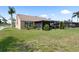 Expansive backyard features a screened-in lanai, lush lawn, and tropical landscaping, perfect for outdoor living at 7923 Woburn St, New Port Richey, FL 34653