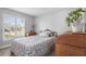 Light-filled bedroom with plantation shutters, vintage furniture, and a patterned bedspread at 7923 Woburn St, New Port Richey, FL 34653