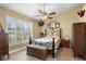 Bedroom with plantation shutters, ceiling fan, and bed with decorative pillows and a bench at 7923 Woburn St, New Port Richey, FL 34653