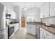 Bright kitchen features white cabinetry, stainless steel appliances, and neutral countertops at 7923 Woburn St, New Port Richey, FL 34653