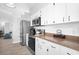 Kitchen featuring updated stainless steel appliances, bright white cabinets, and neutral countertops at 7923 Woburn St, New Port Richey, FL 34653